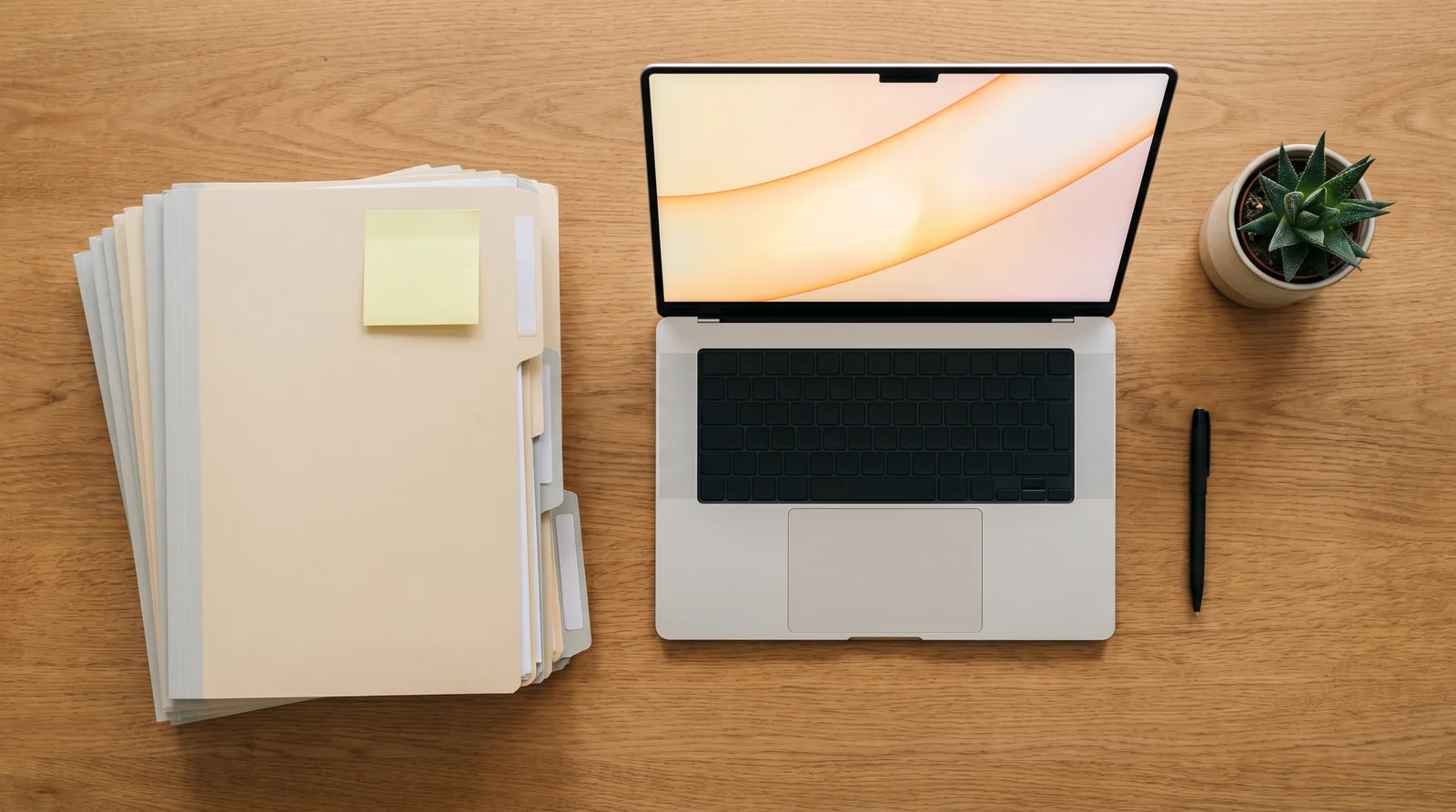Schreibtisch mit Patientenakten und Laptop in einer Arztpraxis, Symbol der Dokumentationslast
