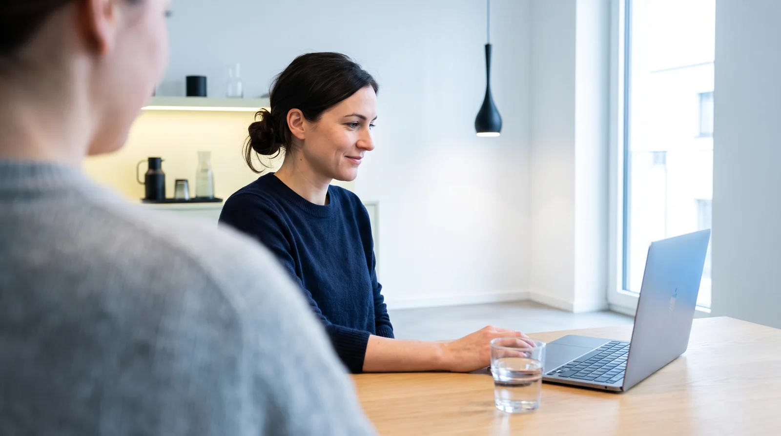 Servicemitarbeiterin bearbeitet konzentriert eine Kundenanfrage am Laptop im modernen Büro